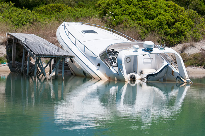 boat sinking next to a dock
